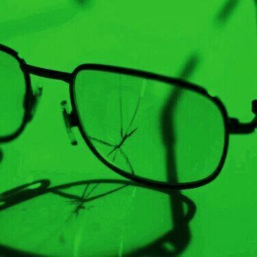 a pair of glasses sitting on top of a green table next to a computer mouse