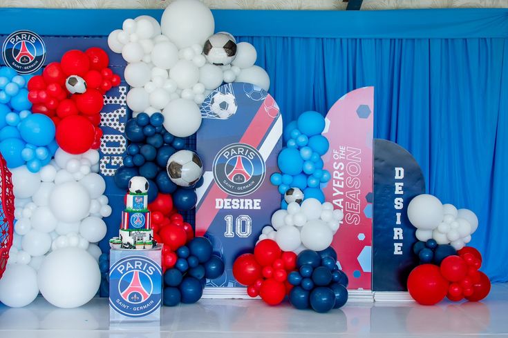 balloons and streamers decorate the stage for a paris soccer team themed birthday party in red, white, and blue