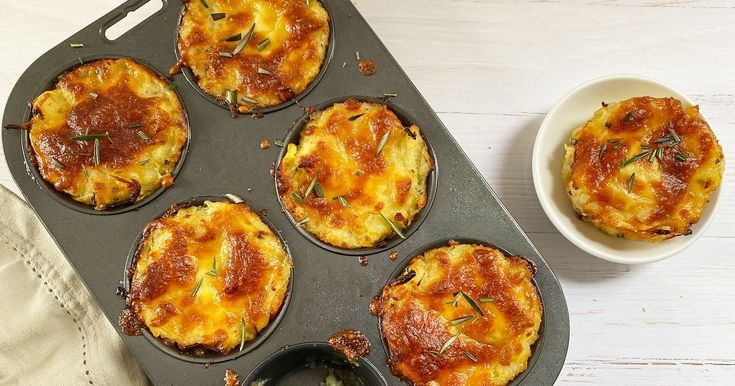 an overhead view of mini quiches in a muffin tin on a white table