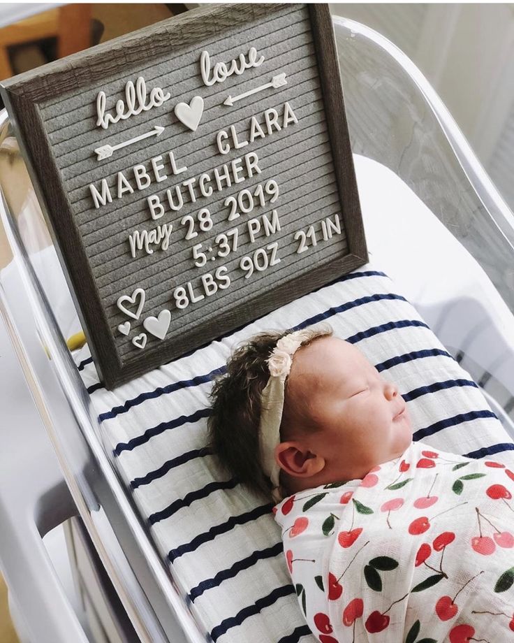 a baby is laying in a crib with his name on the sign above it