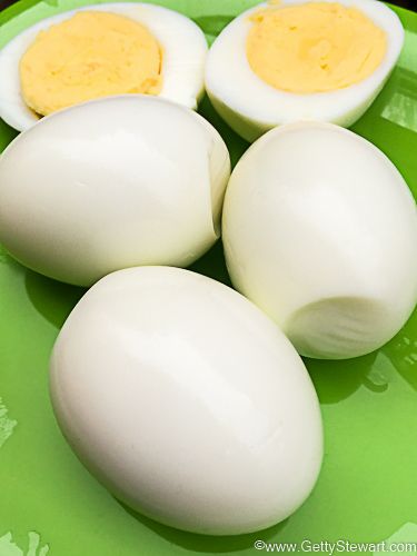 four hard boiled eggs on a green plate