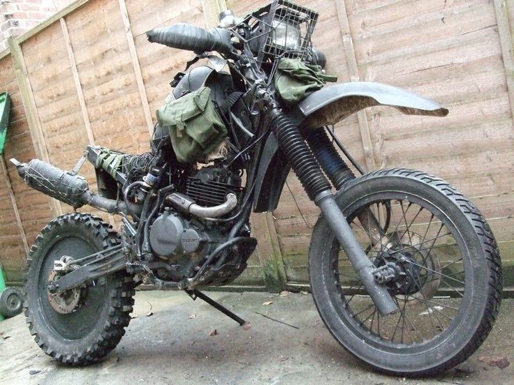 a motorcycle parked in front of a wooden fence