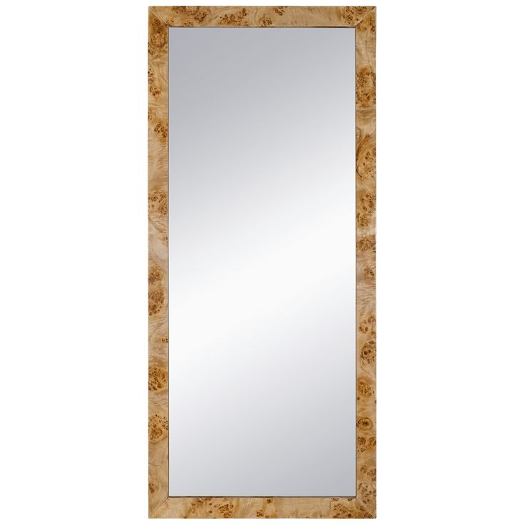 a large mirror sitting on top of a white wall next to a wooden framed frame