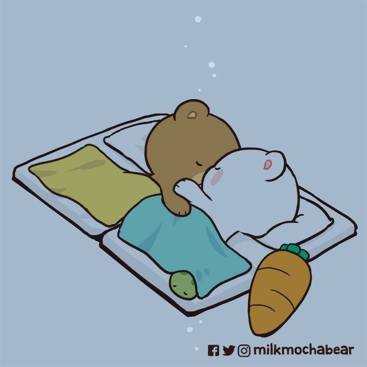 a teddy bear sleeping on top of a bed next to a carrot