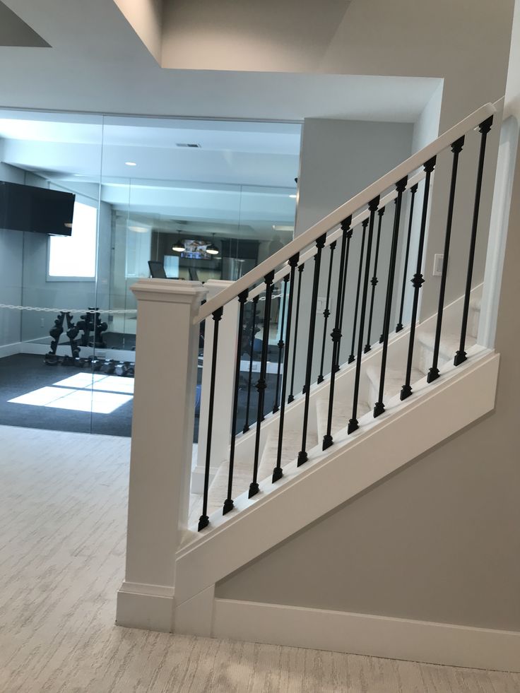 an empty living room with white walls and black railings