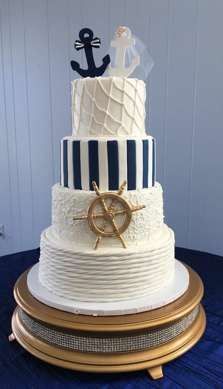 a three tiered cake with an anchor and ship's wheel on the top