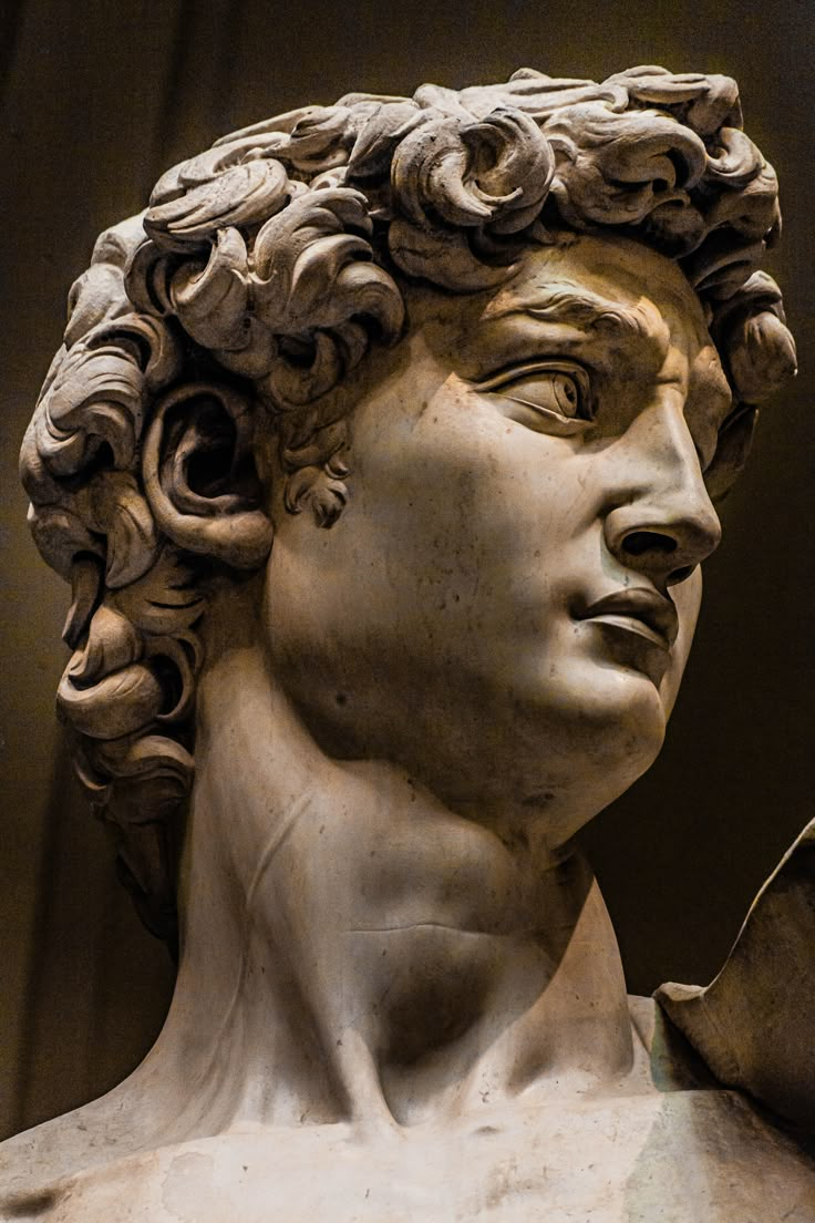 a close up of a statue of a man's head with curls on his hair