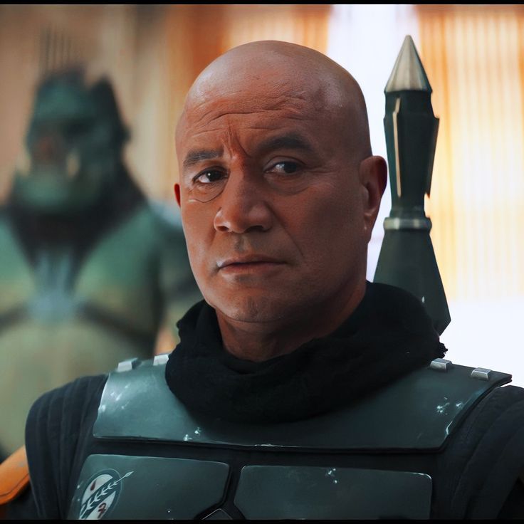 a bald man in a star wars costume looks at the camera while standing next to an alien