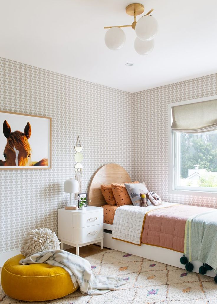 a bedroom with two beds and a yellow ottoman in front of the bed is an animal print wallpaper