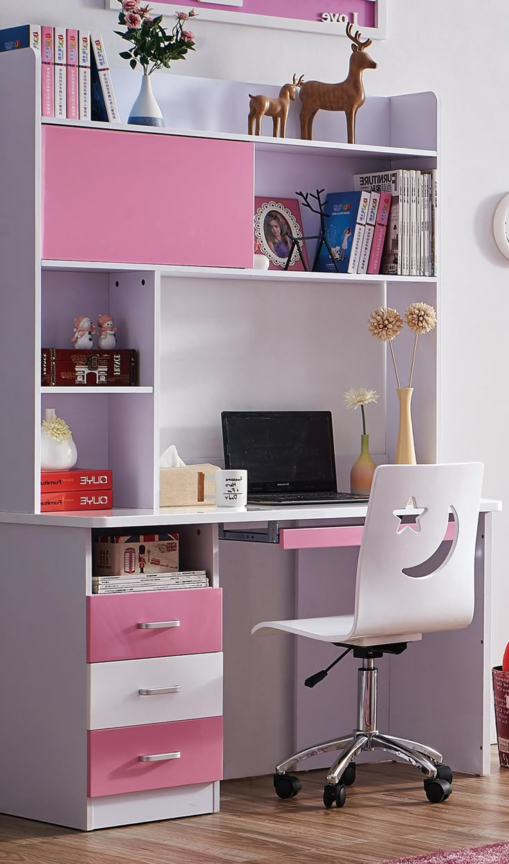 a pink and white desk with a laptop on it in front of a bookshelf