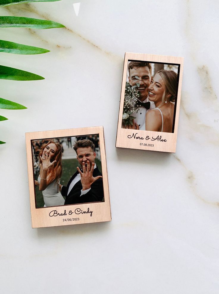 two wooden photo frames with the words guest and wedding printed on them next to a plant