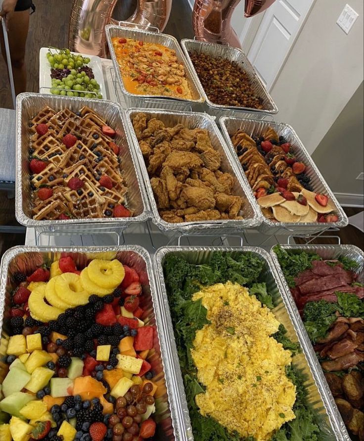 several trays filled with different types of food on top of a table next to each other