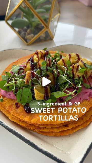 a plate topped with food on top of a white table next to a vase filled with flowers