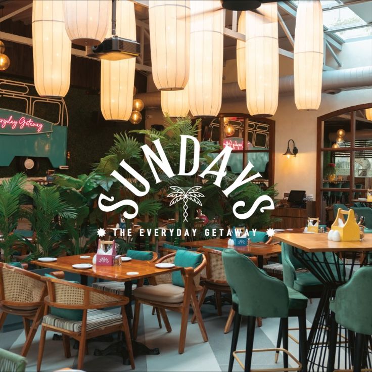 the inside of a restaurant with tables, chairs and lights hanging from the ceiling above