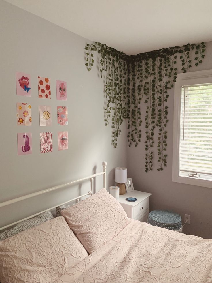 a bed sitting under a window next to a wall with pictures hanging on the walls