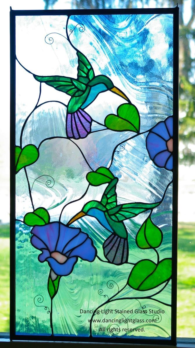 a stained glass window with blue flowers and green leaves