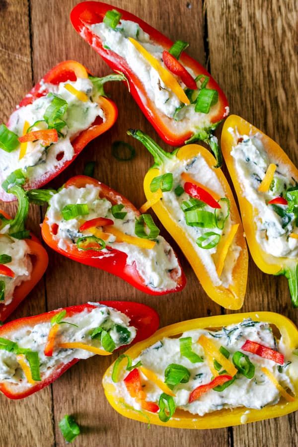 stuffed bell peppers with cheese and vegetables on a wooden table, ready to be eaten