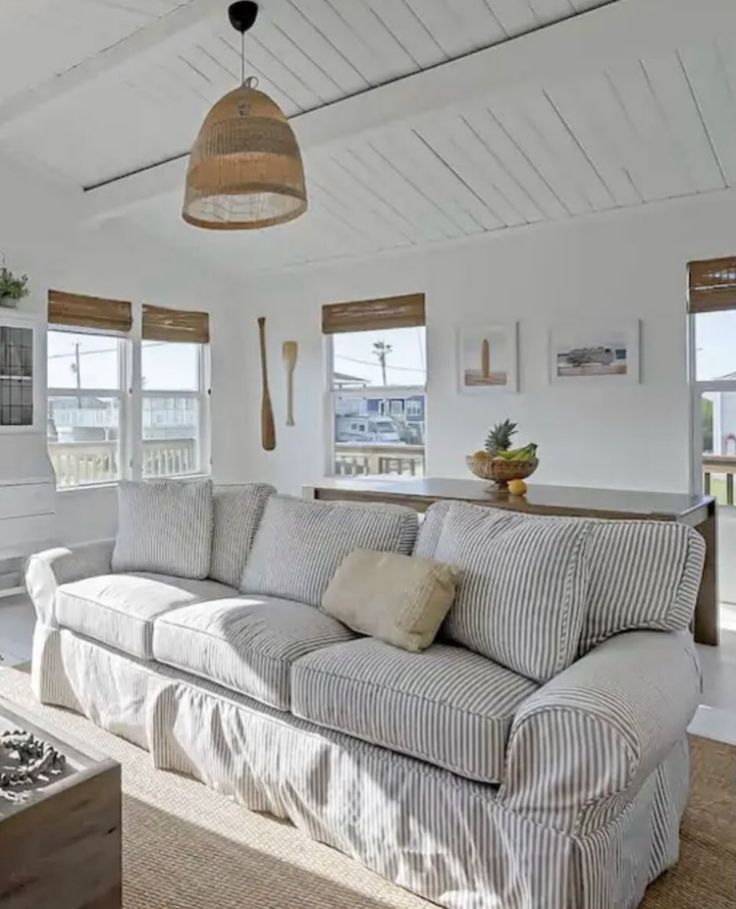 a living room filled with furniture and lots of windows