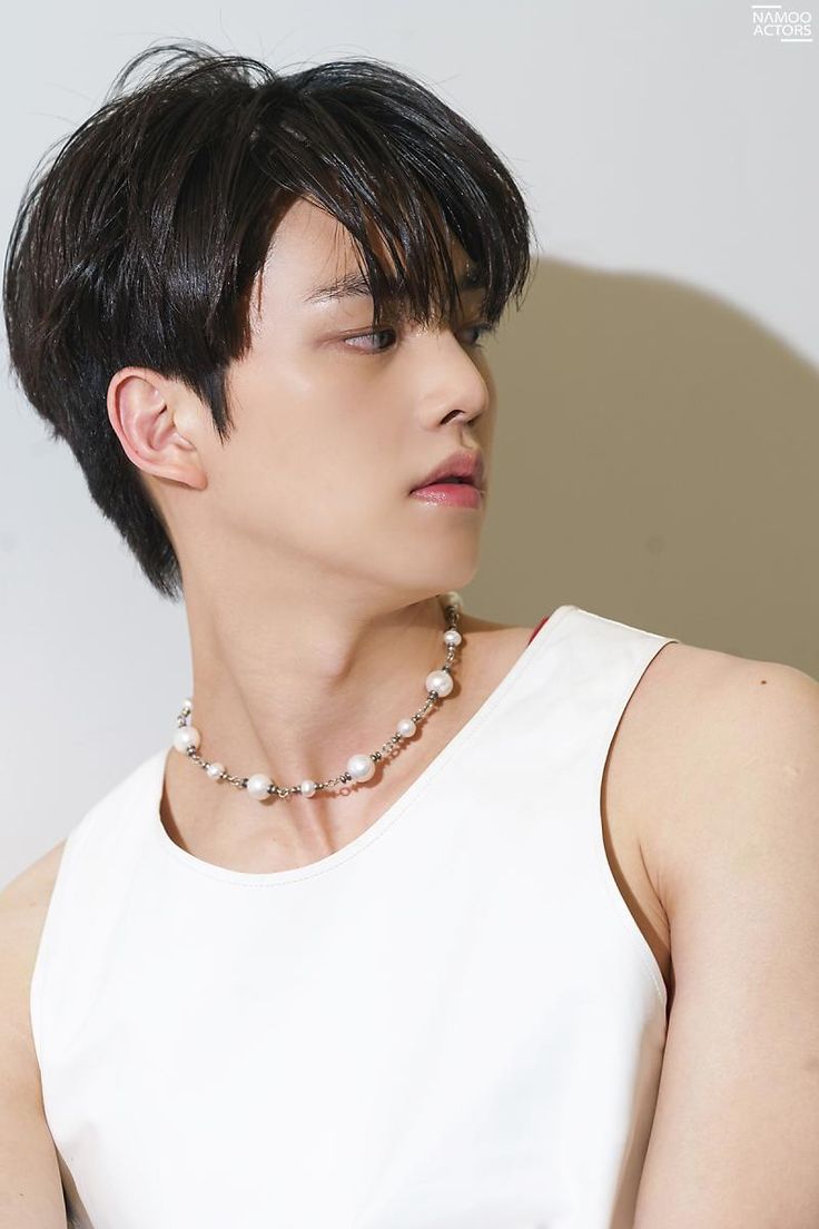 a young man wearing a necklace with pearls on it's neck and his eyes closed