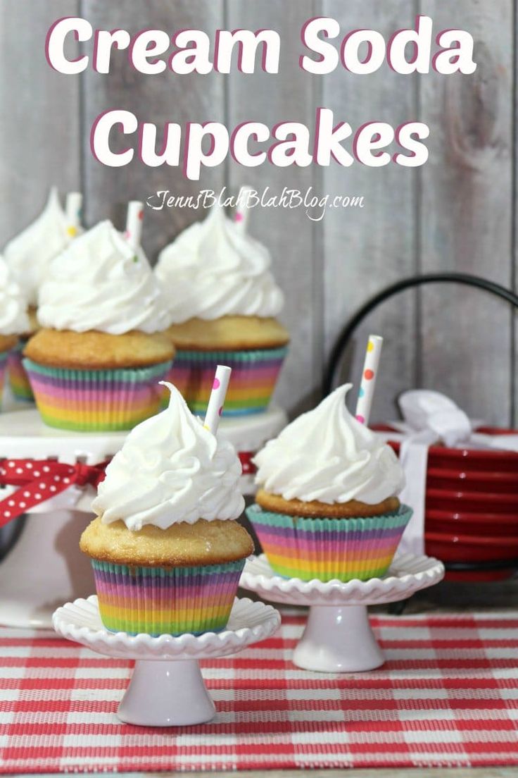 some cupcakes with white frosting on top are sitting on a red and white checkered tablecloth