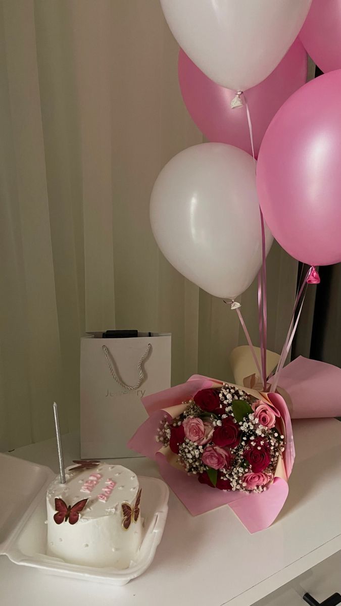 a birthday cake and balloons on a table