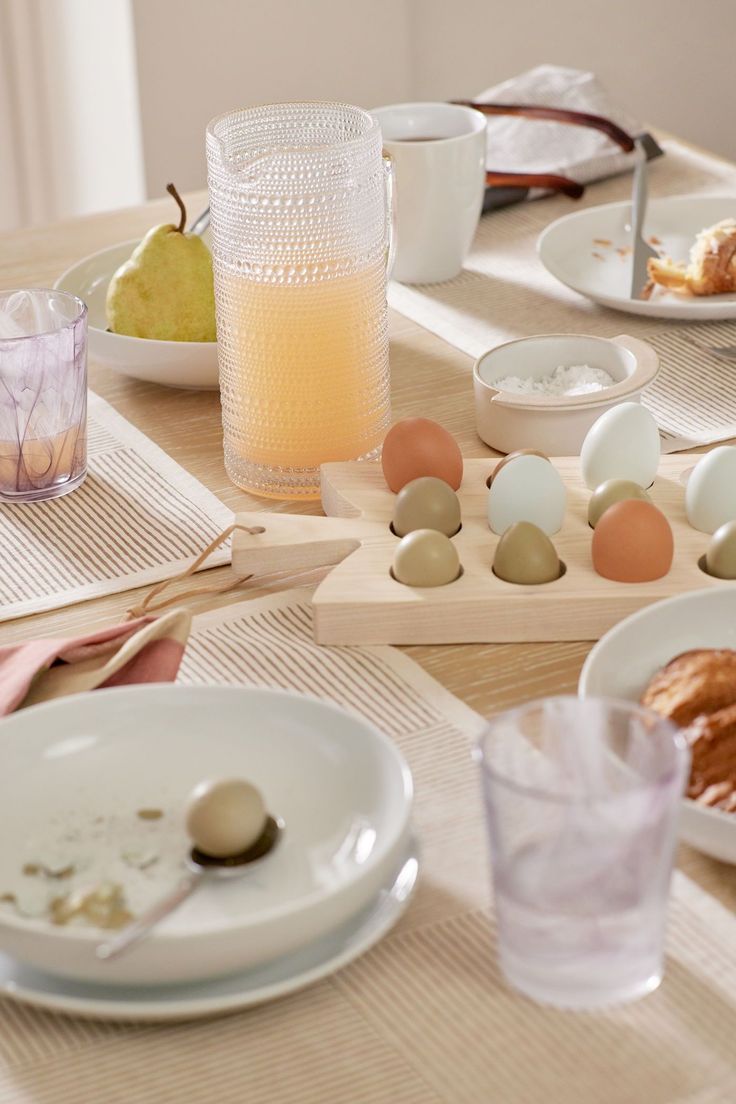 the table is set with eggs, croissants and other breakfast foods on it