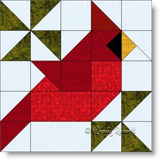 a red bird sitting on top of a patchwork quilt