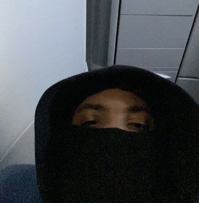 a person wearing a black hood and covering their face