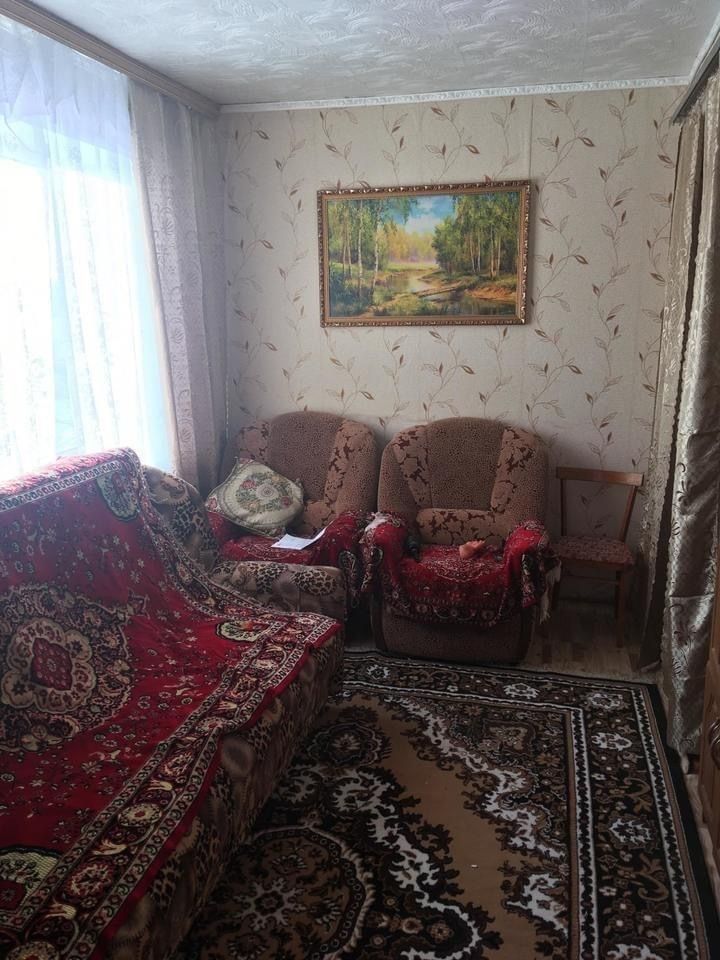 a living room with couches and rugs in front of a painting on the wall