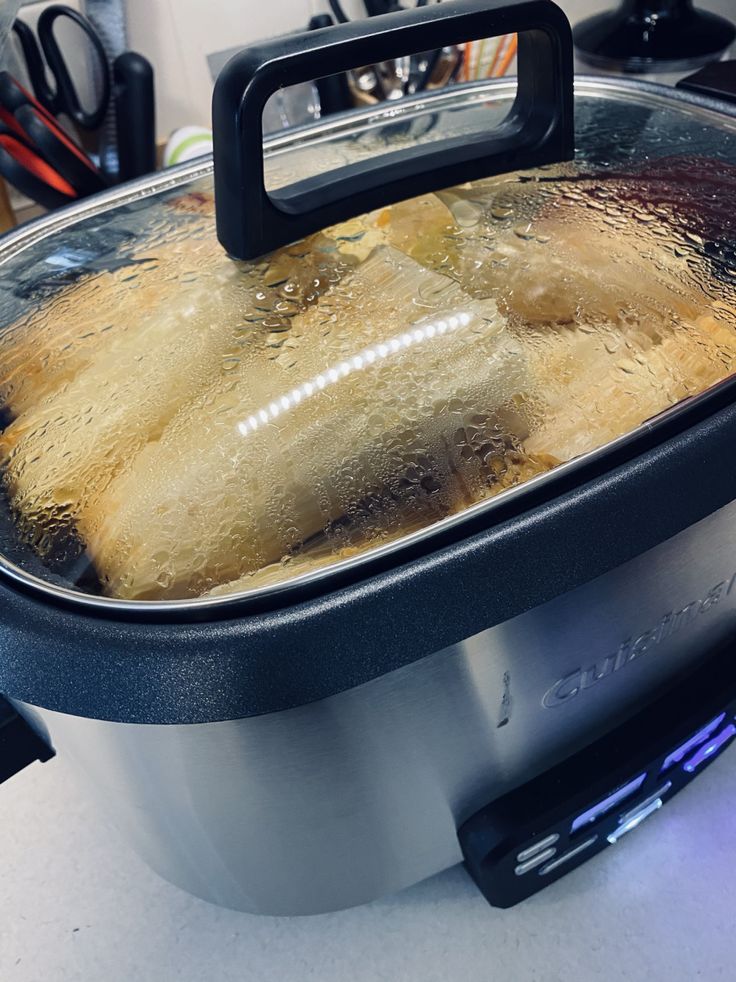 an open crock pot filled with food on top of a counter