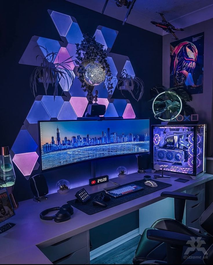 two computer monitors sitting on top of a desk in front of a purple and blue wall