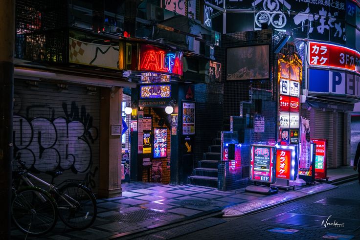 a city street at night with neon signs