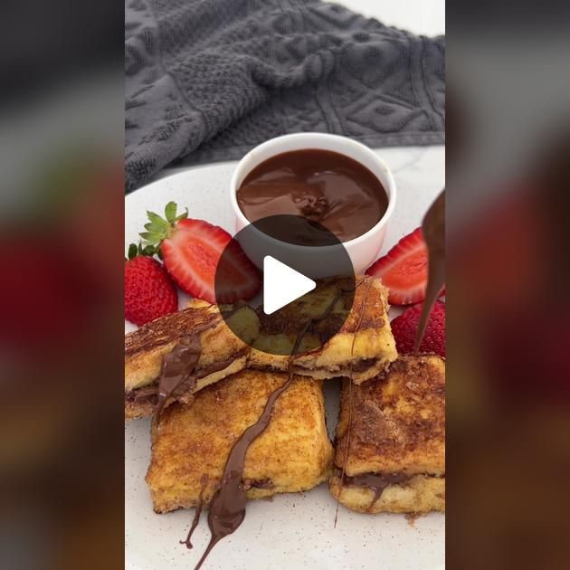 french toast with chocolate sauce and strawberries on the side is featured in this video