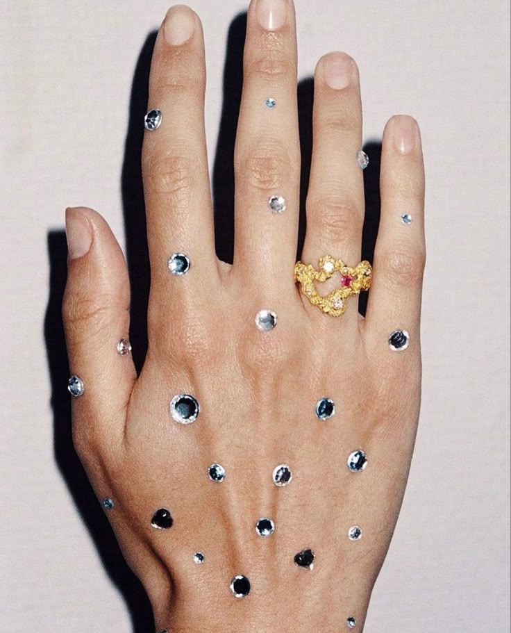 a woman's hand with diamond and gold rings on her left hand, holding onto the other hand