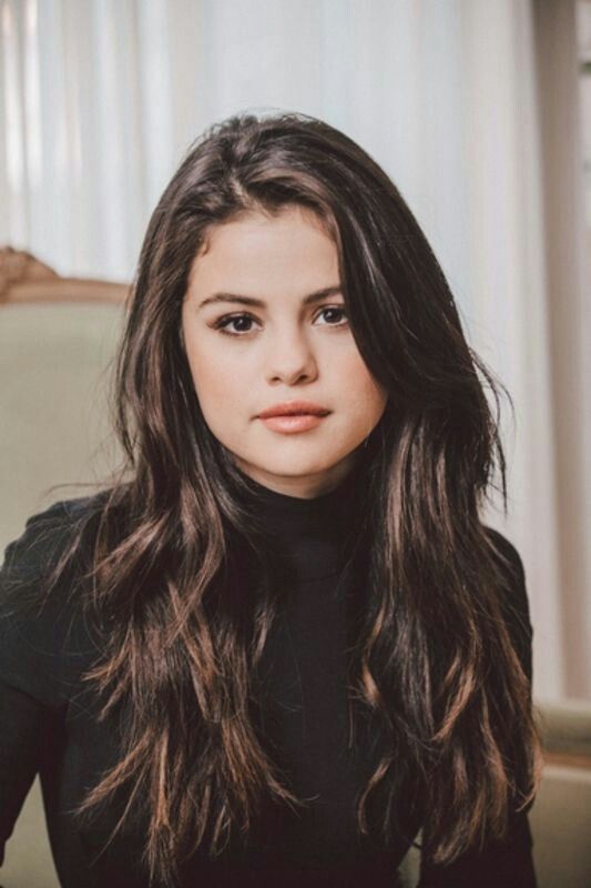 a woman with long hair sitting on a couch