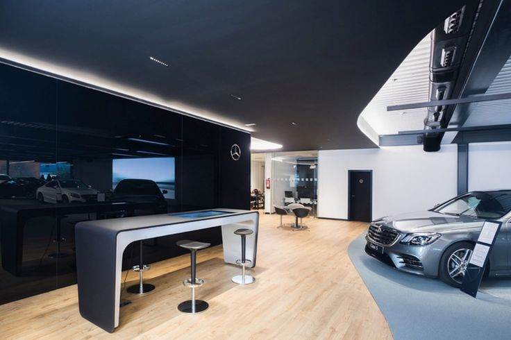 a car showroom with two cars parked in it