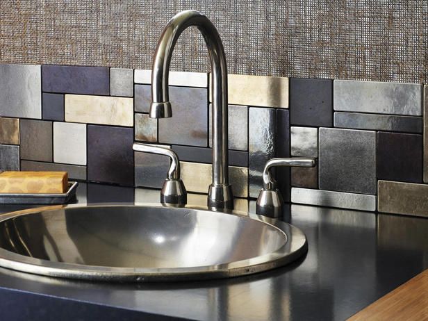 a stainless steel sink and faucet in a kitchen with tile backsplash