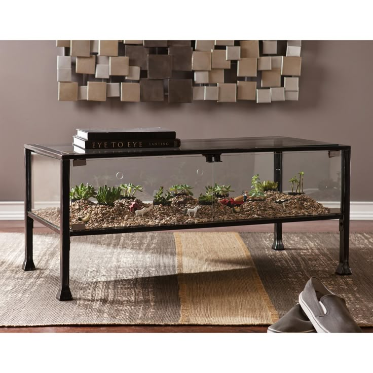 a coffee table with plants and rocks on it in front of a wall mounted mirror