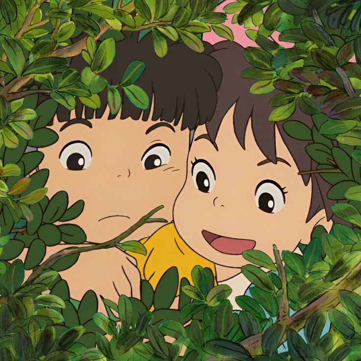 two children peeking out from behind some leaves