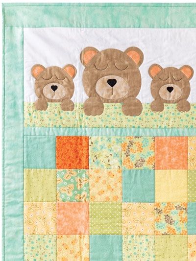 three teddy bears are sitting on top of a patchwork quilted wallhange