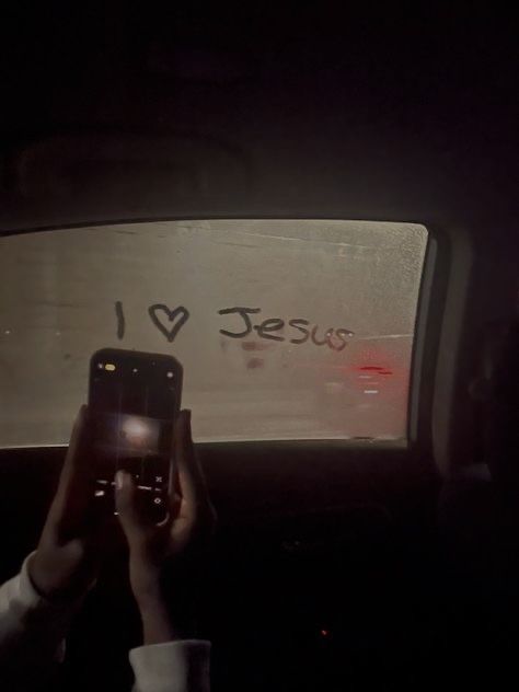 someone taking a photo in the back seat of a car at night with their cell phone