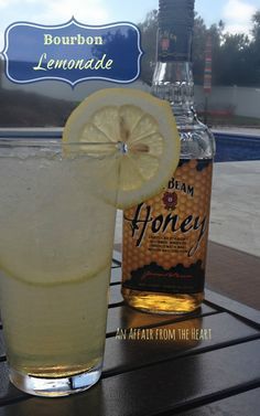 a bottle of lemonade sitting next to a glass filled with liquid