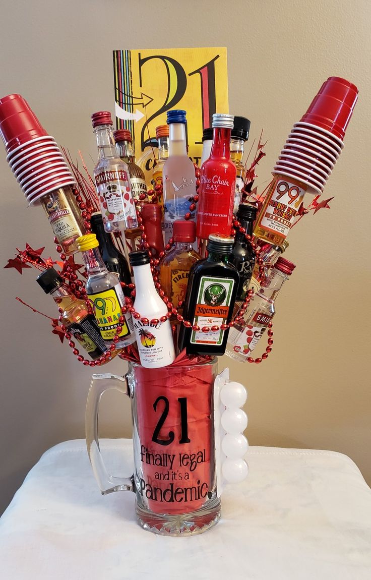 a glass mug filled with liquor and condiments on top of a white table