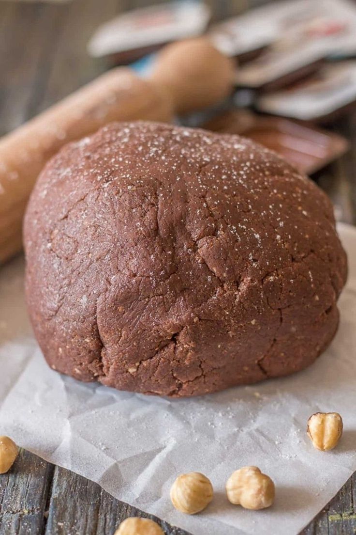 a loaf of bread sitting on top of a piece of paper next to some nuts