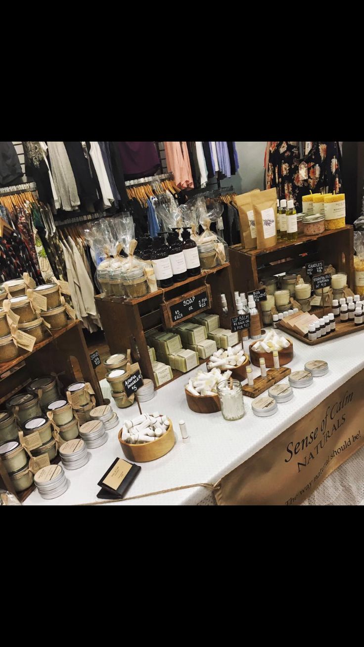 the table is full of different types of items for sale at the market, including candles and soaps