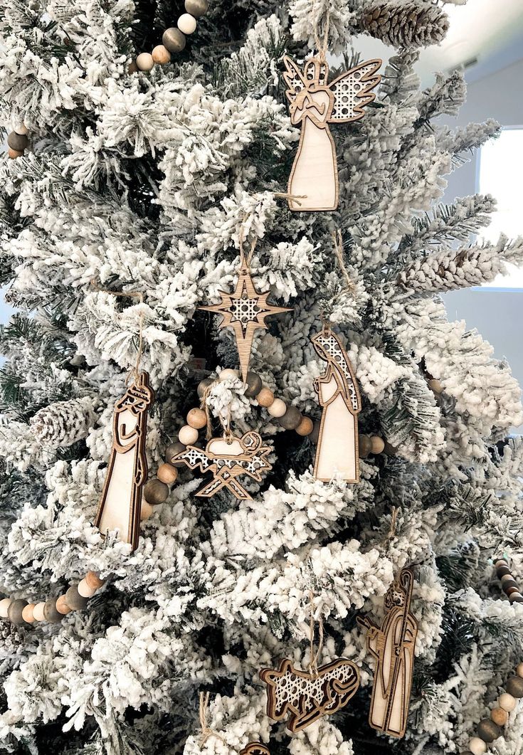 a christmas tree with ornaments hanging from it's branches and an angel ornament on the top