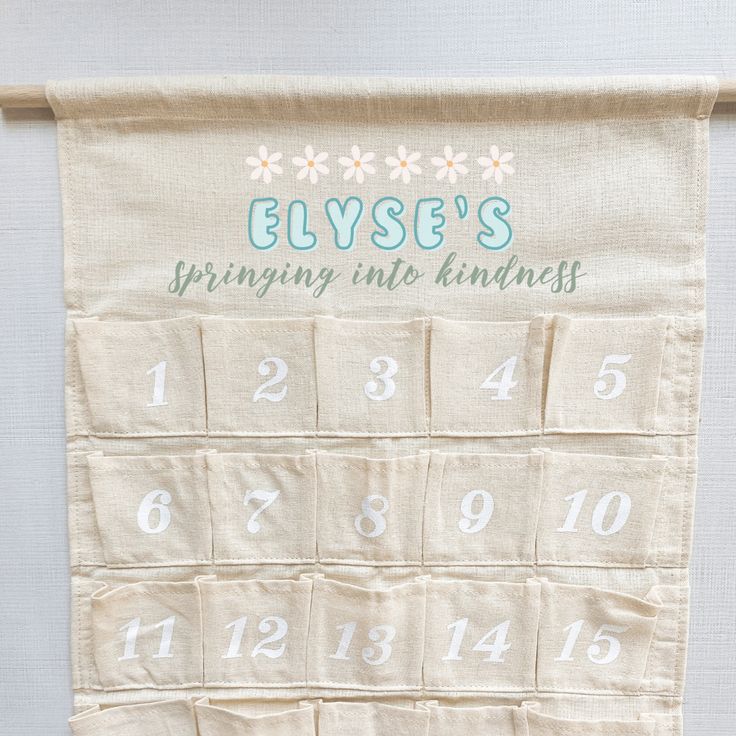 a towel hanging on the wall with numbers written in white and green lettering that reads elyse's spring into kindness