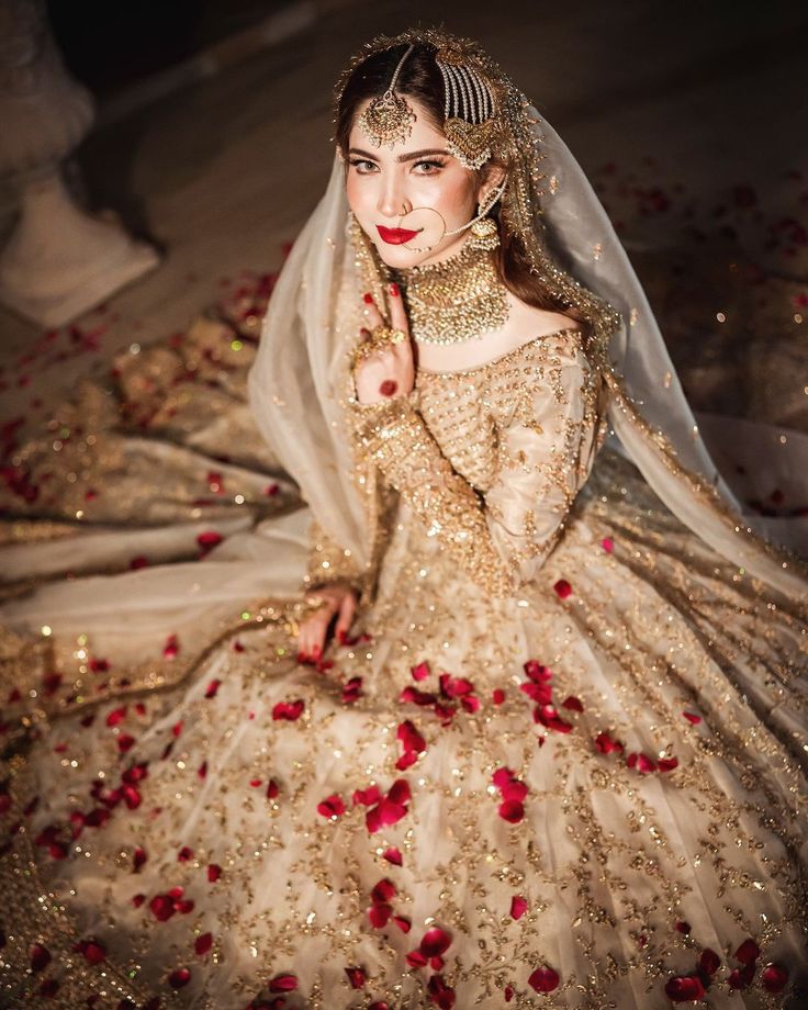 a woman in a wedding dress with roses on the floor and veil over her head