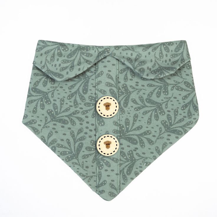 a dog bandana with two buttons on it's side and a green paisley pattern