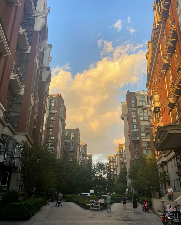 people are walking down the street in front of tall buildings